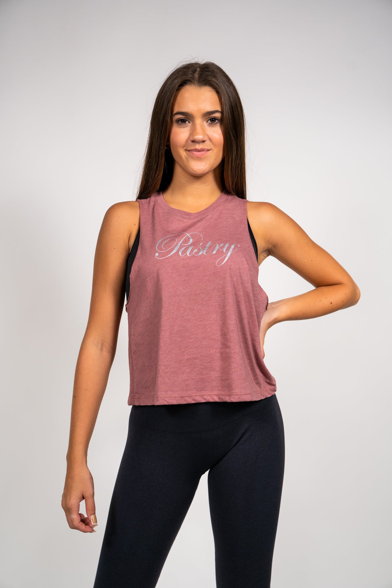 Woman wearing Pastry Cropped Racerback Tank Top Heather Mauve with Silver Logo front view