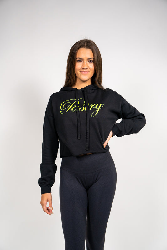 Woman wearing Pastry Cropped Hoodie Black with Neon Green Logo front view